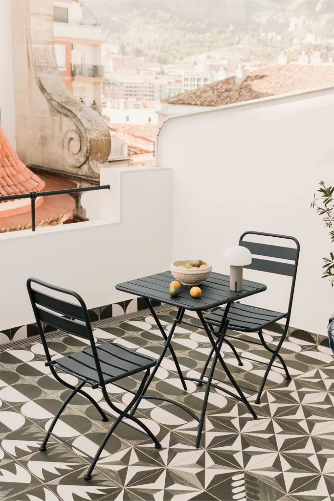 Conjunto de mesa dobrável de jardim e 2 cadeiras Janti, em aço com acabamento em pintura eletrostática, ideal para decorar pequenos terraços devido ao seu design prático, resistente e elegante.