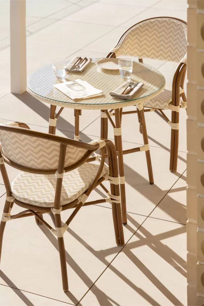 Conjunto de mesa redonda e 2 cadeiras empilháveis ​​com braços em alumínio Brielle Bistro, perfeito para decorar terraços e espaços exteriores funcionais e elegantes.