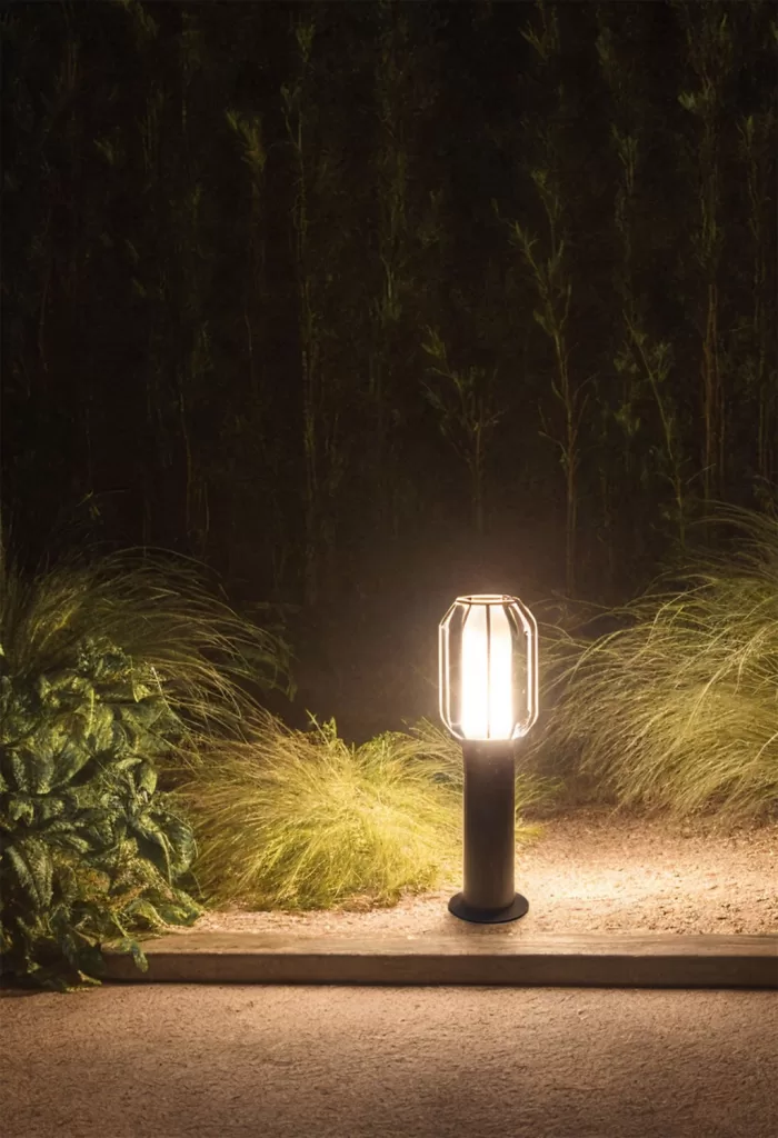 Baliza de exterior iluminando un jardín con luz blanca