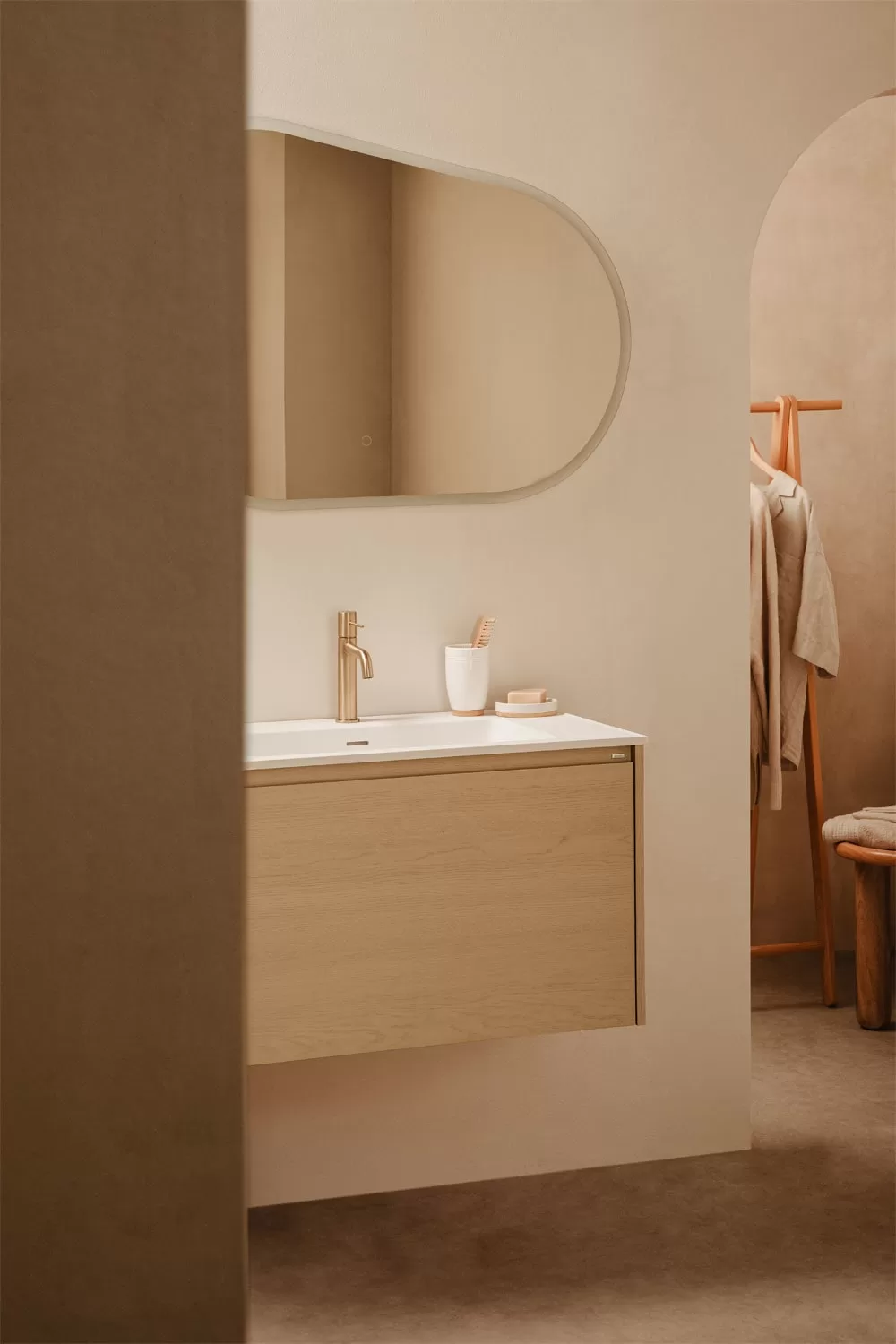 Sanitario compacto en baño pequeño moderno con mueble flotante de madera clara y espejo orgánico. Diseño elegante y funcional que optimiza el espacio.